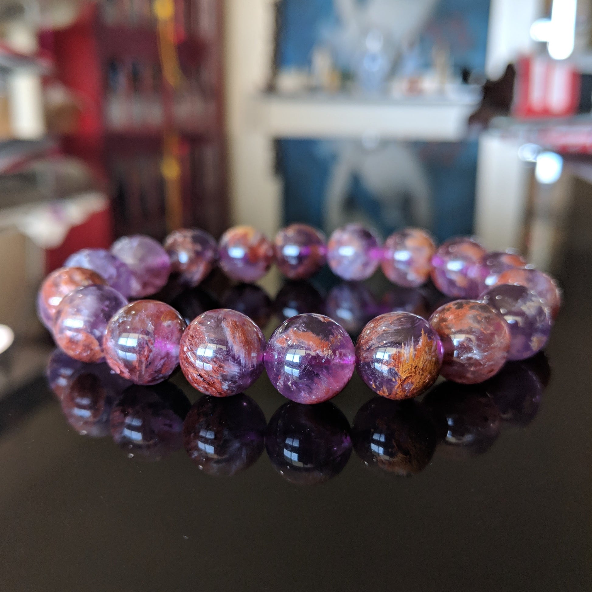 This picture illustrates the Auralite 23 on a flat black surface.  The bracelet is mainly bronze and Amethyst color.  It is excellent quality. 