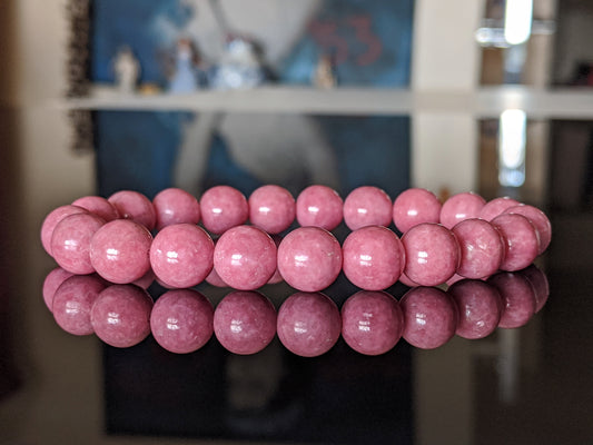 This is the main picture for the Rhodonite bead bracelet.  It is of the highest quality available on beads, and the item is shown on a flat black surface.  Its color is a heart warming pink.   Excellent material.