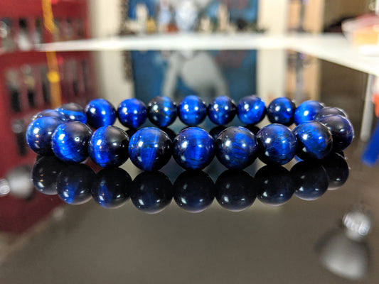 This is the main picture for the blue Tiger Eye bead bracelet.  It is displayed on a flat black surface.  The beads are natural Tiger Eye, color enhanced.  You will be very happy with this product. 