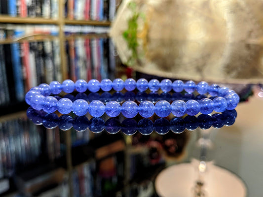 This is the main picture for the purple-blue Tanzanite 6mm bead bracelet.  The bracelet is displayed on a black flat surface, and the material is well made with excellent natural Tanzanite. 