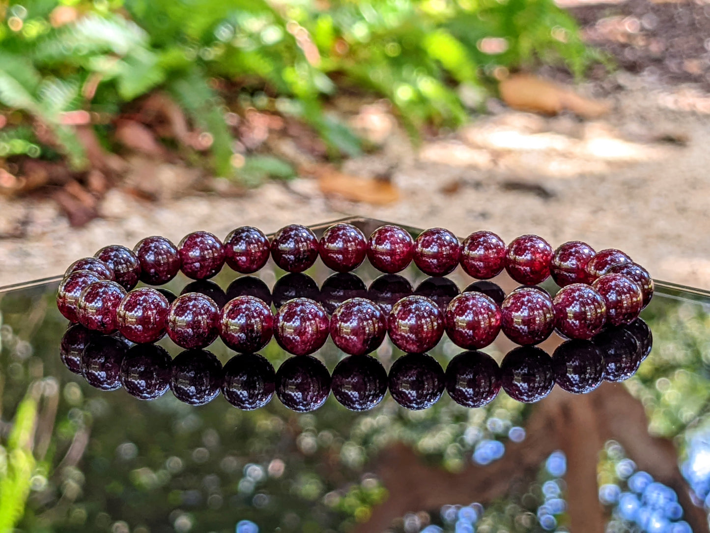 This is the main picture for the 8mm size Garnet bracelet.   The Garnet is displayed on a black flat surface, and the deep burgundy color is excellent.  The bead bracelets are strung on durable stretch cord.  RayonBracelet.com