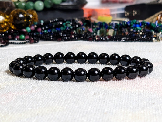 This is the main picture for the Black Onyx bead bracelet.  It is dsplayed on a white surface.  The black is completely uniform through out the bead, and it has excellent luster.  It is our best value item. 